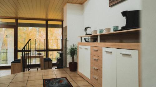 een keuken met witte kasten en een woonkamer bij Ferienwohnungen Bullau in Erbach