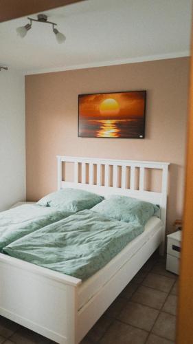 a bed in a bedroom with a picture on the wall at Ferienwohnungen Bullau in Erbach