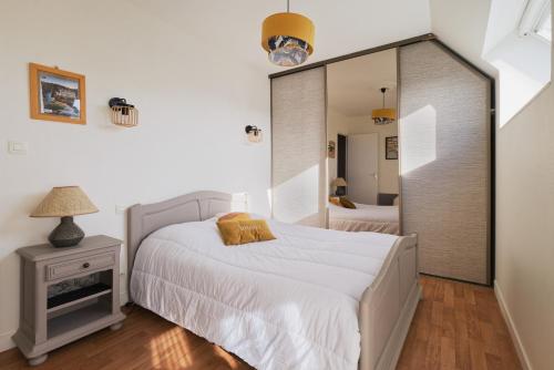 a bedroom with a bed and a large mirror at Gîte l'orée de la forêt légendaire in Néant-sur-Yvel