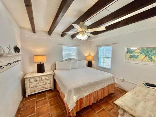 a bedroom with a bed and a ceiling fan at Baked and Barefoot Beach Bunglows in St. George Island