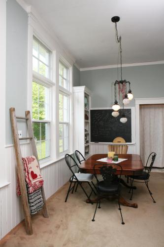 a dining room with a table and chairs and a chalkboard at Picturesque School House Retreat in Meaford