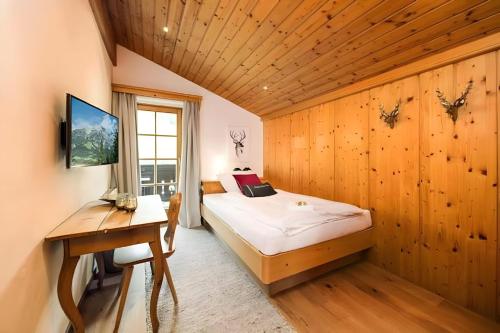 a bedroom with a bed and a desk in a room at Chalet Steinberg in Leogang