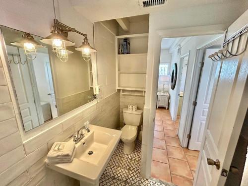 een badkamer met een wastafel, een toilet en een spiegel bij Baked Beach Bungalow in St. George Island