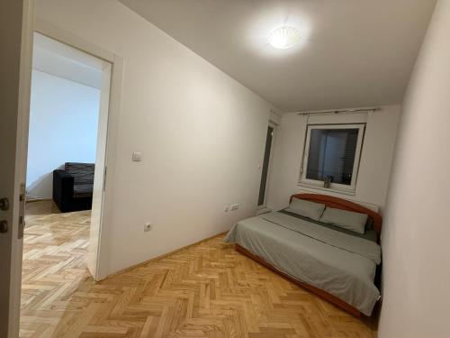 una stanza bianca con un letto e una finestra di Xenia a Bijeljina