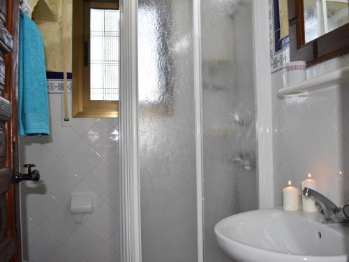 a bathroom with a sink and a shower with candles at Finca La Jara with private Pool in Cómpeta