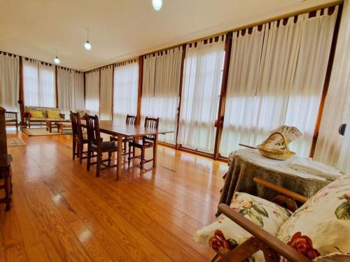 ein Wohnzimmer mit Tisch und Stühlen und Fenstern in der Unterkunft Casa Rural Los Monteros in Espinosa de los Monteros