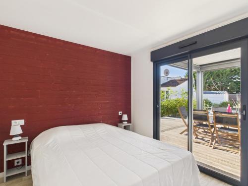 ein Schlafzimmer mit einem Bett und einer roten Wand in der Unterkunft Chalet pour 6, domaine avec piscine in Saint-Hilaire-de-Riez