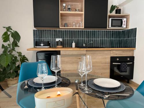 Un comedor con una mesa con vasos y una vela. en Escape Room Codex Verha - Logement insolite Nancy, en Nancy