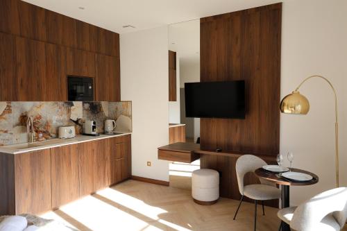 ein Wohnzimmer mit Fernseher und Tisch und Stühlen in der Unterkunft Résidence du Lion in Belfort