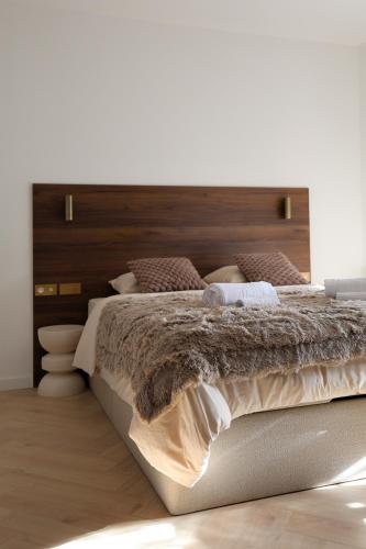 a bedroom with a large bed with a wooden headboard at Résidence du Lion in Belfort