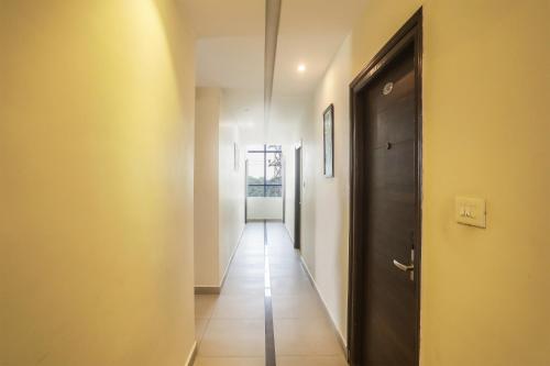 海得拉巴Collection O SSR Royal Suites的走廊有一扇黑色的门和瓷砖地板