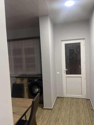 una habitación blanca con una puerta, una mesa y una silla en Gimara Apartments, en Sioni