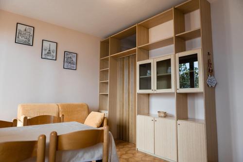 a room with a table and a kitchen with shelves at Holiday Mantovani in Brenzone sul Garda