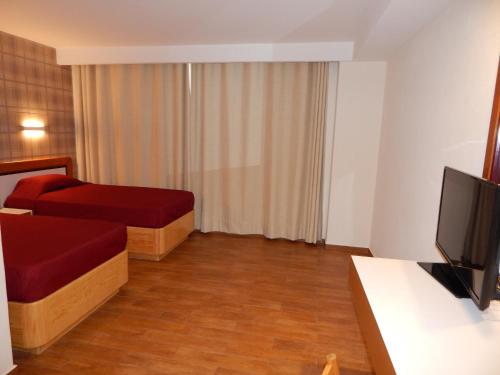 a hotel room with two beds and a flat screen tv at Hotel El Salvador in Mexico City