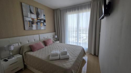 ein Schlafzimmer mit einem Bett mit zwei Handtüchern darauf in der Unterkunft Daniel Apartment vistas al mar in El Borseral