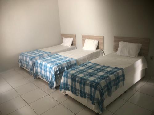 two beds sitting next to each other in a room at Vivenda Hotel in Arapiraca
