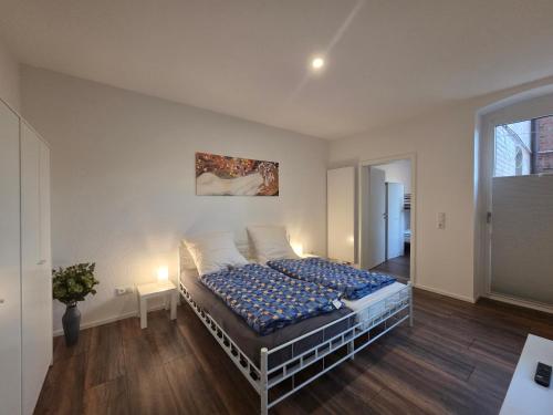 a bedroom with a bed with a blue comforter at Apartment am Saaleradwanderweg in Merseburg