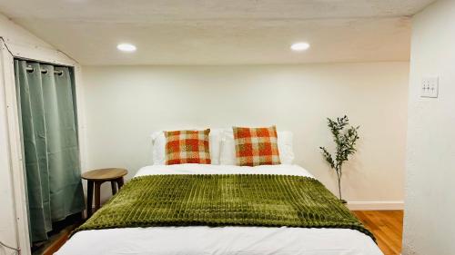 een slaapkamer met een bed met twee kussens erop bij Steps to Kendall, MIT, Green Line in Cambridge