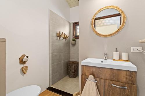 ein Badezimmer mit Waschbecken und Spiegel in der Unterkunft Kas Palma at Waterland's Village - Private pool! in Kralendijk
