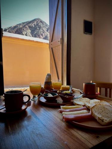 a table with a breakfast of toast and coffee and orange juice at Hostería Los Morteros in Purmamarca