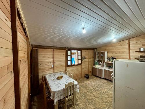 eine kleine Küche mit Tisch und Kühlschrank in der Unterkunft Sítio reservado com piscina in Viamão