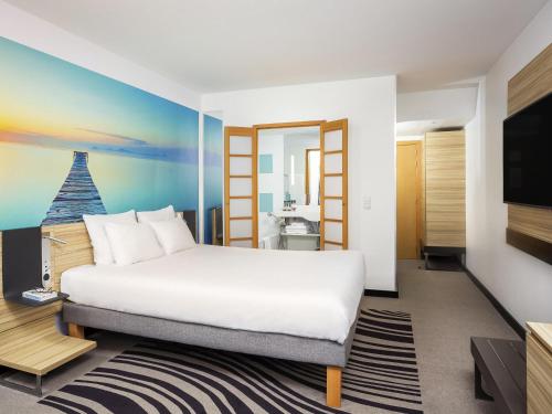 a hotel room with a bed and a tv at Hotel Novotel Brussels Off Grand Place in Brussels