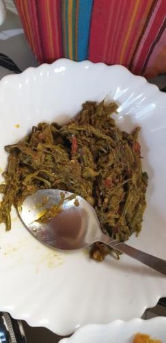 a spoon sitting on a white plate with food at Naran Mountain Chalets in Dargai