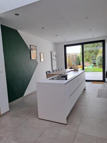 a kitchen with a white counter and a large window at Grande maison familiale à Theux in Theux