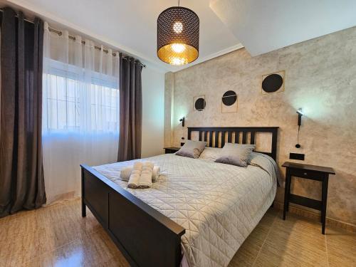 a bedroom with a large bed and a large window at Piso Romántico con piscina in Formentera de Segura