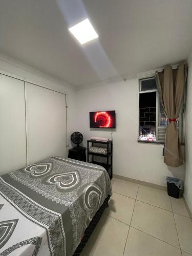 a bedroom with a bed and a tv on the wall at Espaço farol in Aracaju