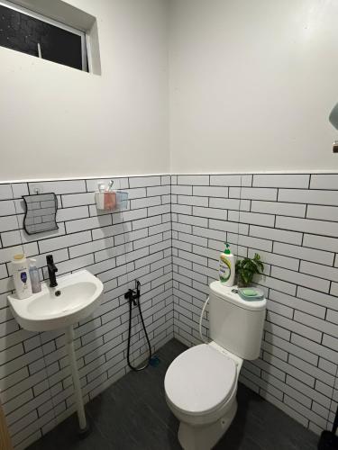 a bathroom with a toilet and a sink at Aufa House in Padang Rengas