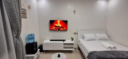 a bedroom with a bed and a fire painting on the wall at Bliss Stay Ruaka in Ruaka