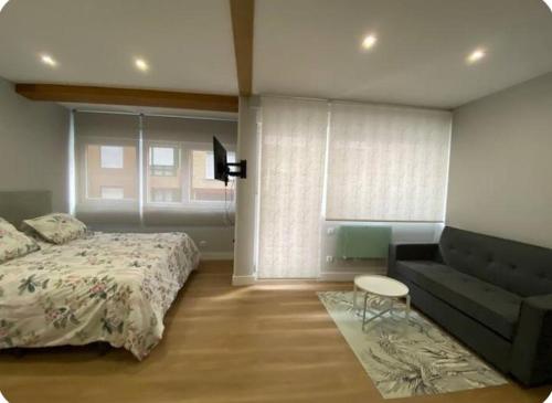 a bedroom with a bed and a couch at Alojamiento con encanto in Santoña