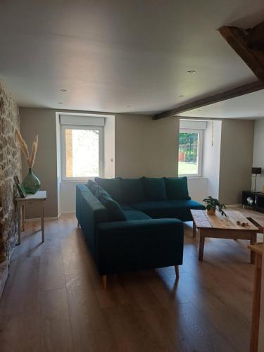 a living room with a blue couch and a coffee table at La belle cachée in Sévérac d' Aveyron
