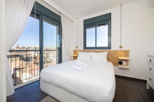 JLM market suite في القدس: غرفة نوم بسرير أبيض ونافذة كبيرة