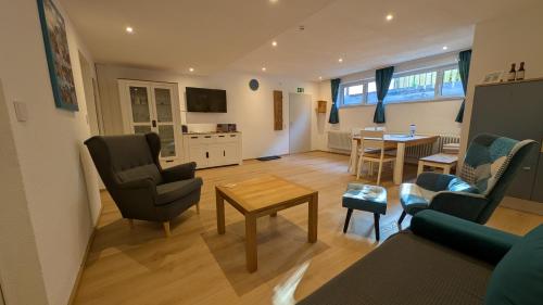 a living room with a couch and chairs and a table at Zentrumsnahe, ruhige Souterrainwohnung AlBaggers in Dinkelsbühl