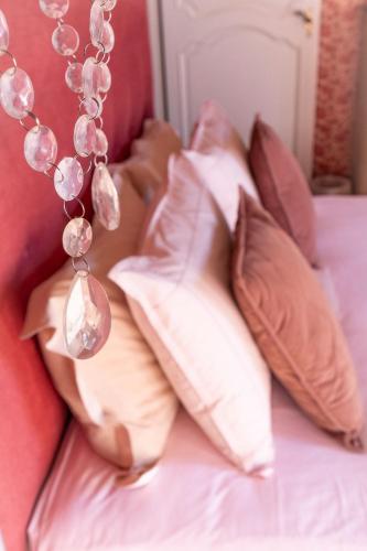 a bunch of pillows on a bed with a necklace at Le Clos Cathala Chambres d'Hôtes in Saint-Paul-de-Jarrat