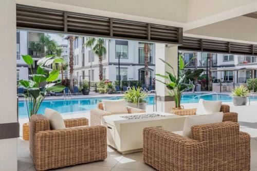 a patio with wicker chairs and a table and a pool at The Edge at Millenia in Orlando