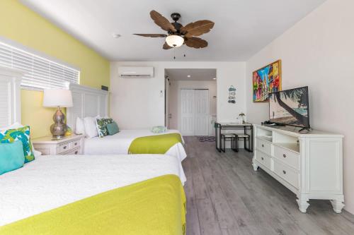 ein Schlafzimmer mit zwei Betten und einem Deckenventilator in der Unterkunft The Banana Bird at Cottages in Sand Bluff