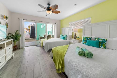 ein Schlafzimmer mit zwei Betten und einem Flachbildfernseher in der Unterkunft The Banana Bird at Cottages in Sand Bluff