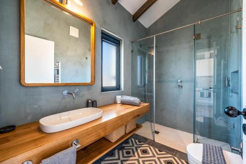 ein Badezimmer mit Waschbecken und Glasdusche in der Unterkunft Monte da Fonte in Zambujeira do Mar