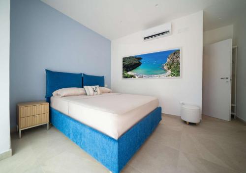 a bedroom with a blue and white bed and a painting at Maison Vittoria in Ischia Town