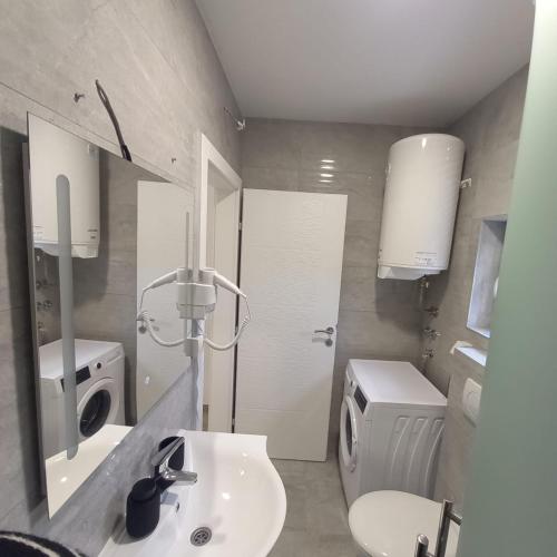 a bathroom with a sink and a washing machine at Apartman Tony in Međugorje