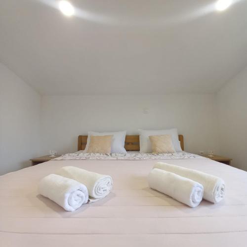 a white bed with two rolled towels on it at Apartman Tony in Međugorje