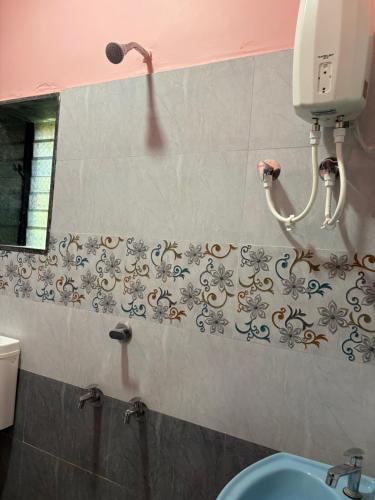 マルバンにあるHotel Vedanshのバスルーム(洗面台付)、壁掛け電話