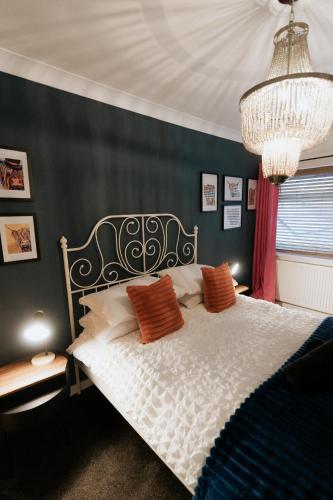 a bedroom with a bed and a chandelier at Marine Cottage 1 - With Private Hot Tub in Newbiggin-by-the-Sea