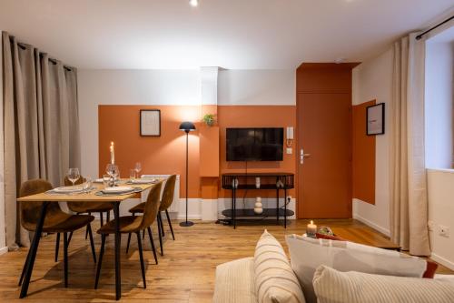 une salle à manger avec une table et des chaises et une télévision dans l'établissement L'Occitane - Grand Studio Chaleureux en Hyper centre, à Castres