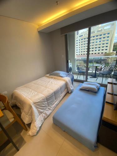 a bedroom with two beds and a large window at Comfortable 2 Bed Apt Steps From Shopping Del Sol in Colonia Lomas Valentinas