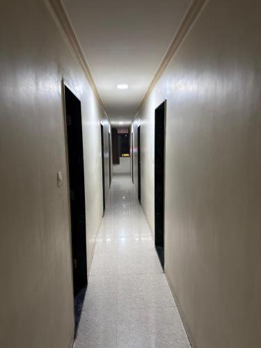 a hallway of a building with two doors and a long corridor at Hotel Royal Inn in Ahmedabad
