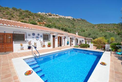 a villa with a swimming pool in front of a house at Casa The Lofties Mit Pool In Andalusien in Comares